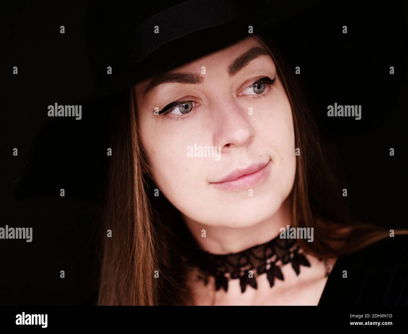 Femme portant un chapeau noir et un choker noir Banque D'Images