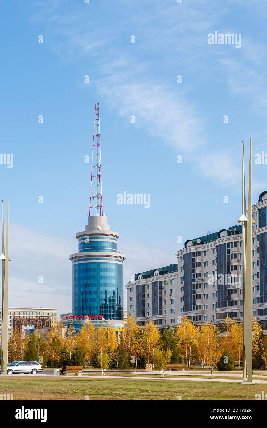 Bâtiment rond moderne revêtu de verre bleu réfléchissant avec mât émetteur de communications dans le centre-ville de Nur-Sultan (Astana), capitale du Kazakhstan Banque D'Images