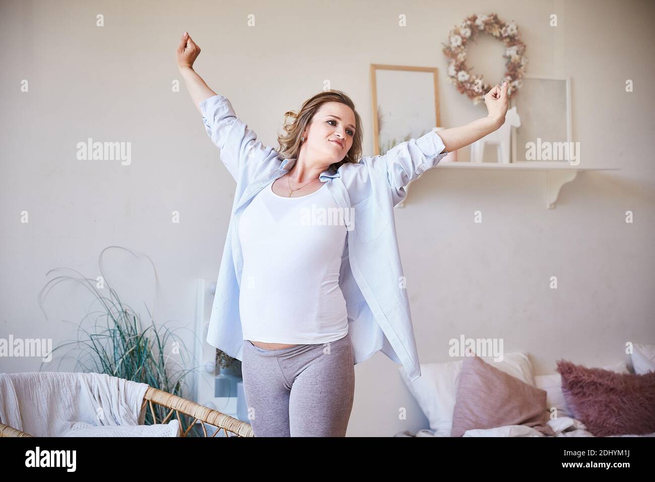 Belle jeune femme enceinte faisant des exercices matinaux à la maison. Grossesse heureuse et saine, concept de paix et de bonheur. Banque D'Images