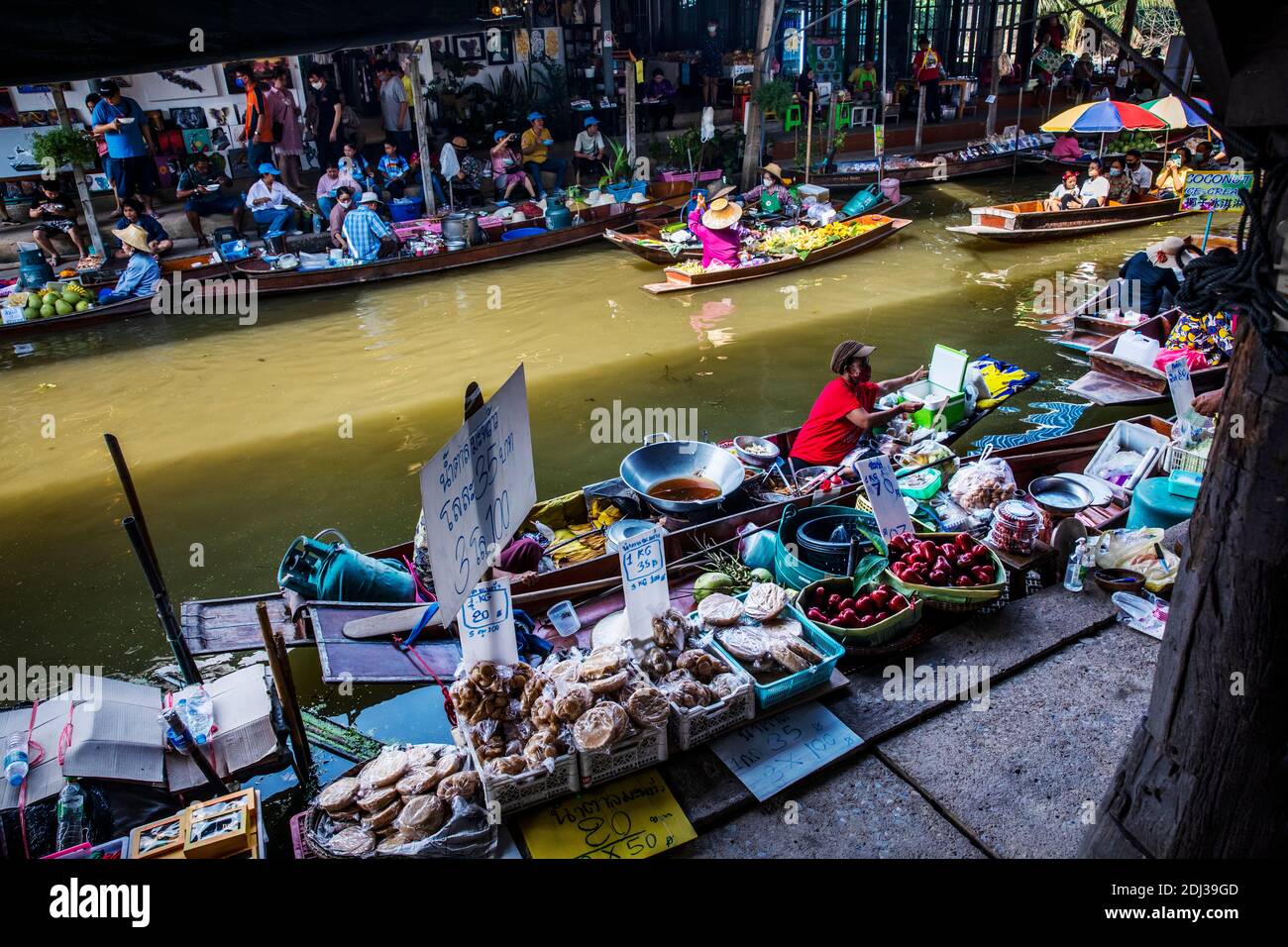 Il y a beaucoup de plats préparés et emballés alignés sur la digue dans le marché flottant de Damnoen près de Bangkok. Banque D'Images