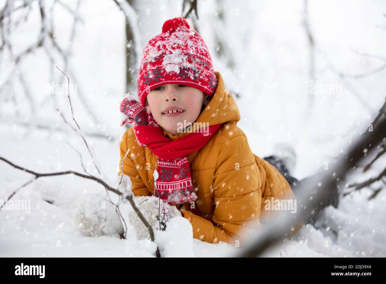 Un garçon heureux dans des vêtements chauds se trouve dans une dérive de  neige. Enfant un jour d'hiver Photo Stock - Alamy