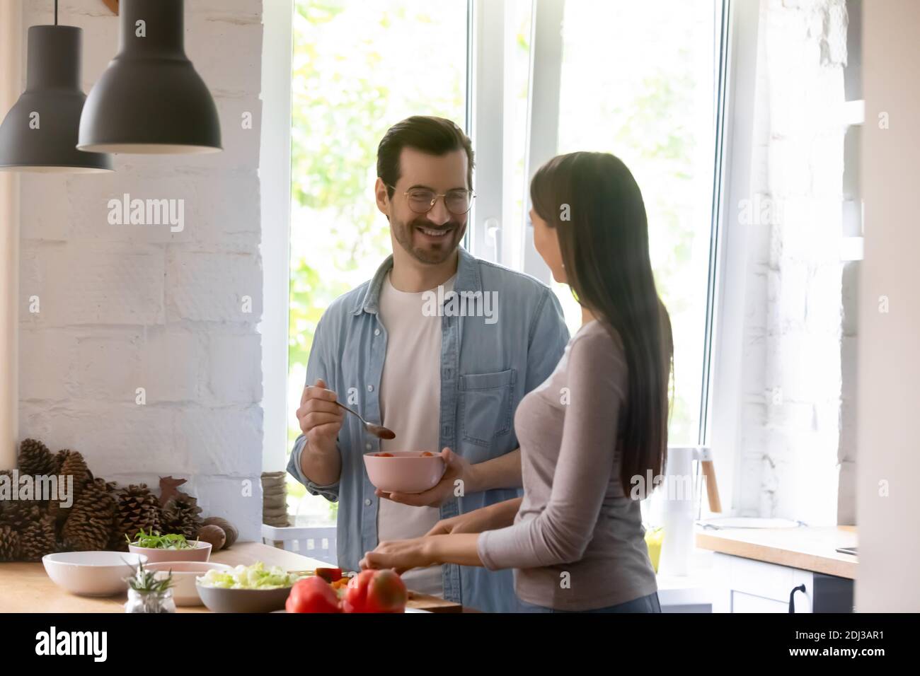 Un homme et une femme heureux qui apprécient les loisirs et qui cuisent la salade ensemble Banque D'Images