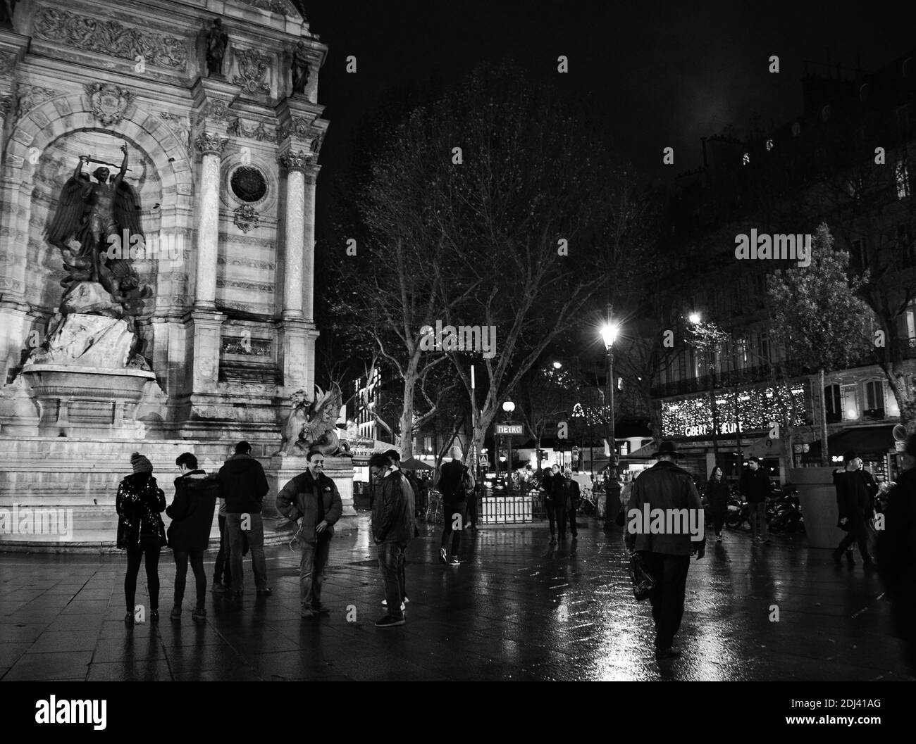 PARIS, FRANCE - 2 DÉCEMBRE 2018 : Tourisme et rencontres locales sur la place Saint Michel le soir. Photo noir et blanc Banque D'Images