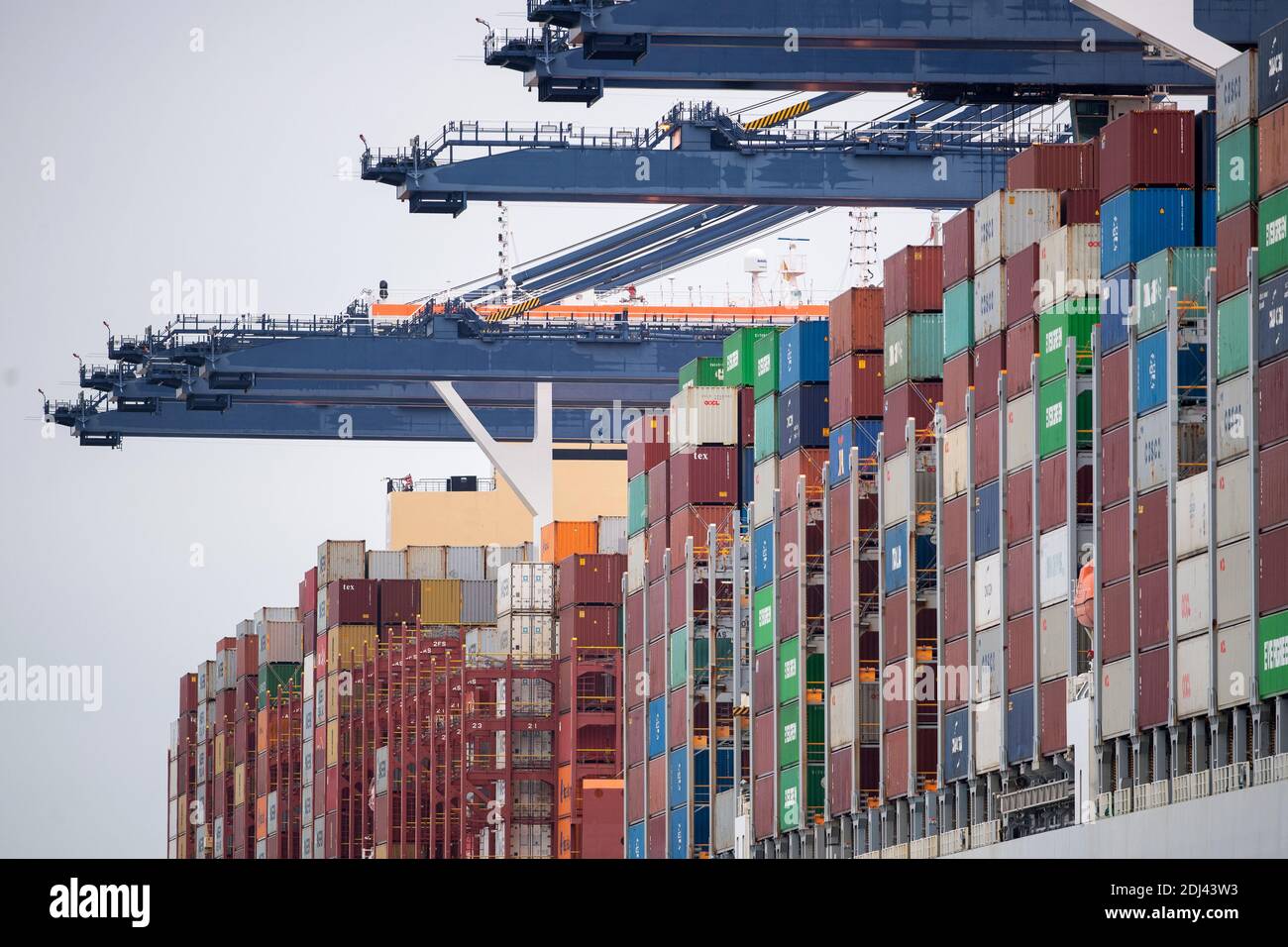 Les conteneurs d'expédition sont déchargés d'un cargo au port de Felixstowe dans le Suffolk. Les expéditions d'équipements de protection individuelle ont obstrué les ports britanniques, ce qui a entraîné d'énormes retards aggravés par les détaillants et les fabricants qui importent des marchandises pour la ruée vers les achats de Noël. Banque D'Images