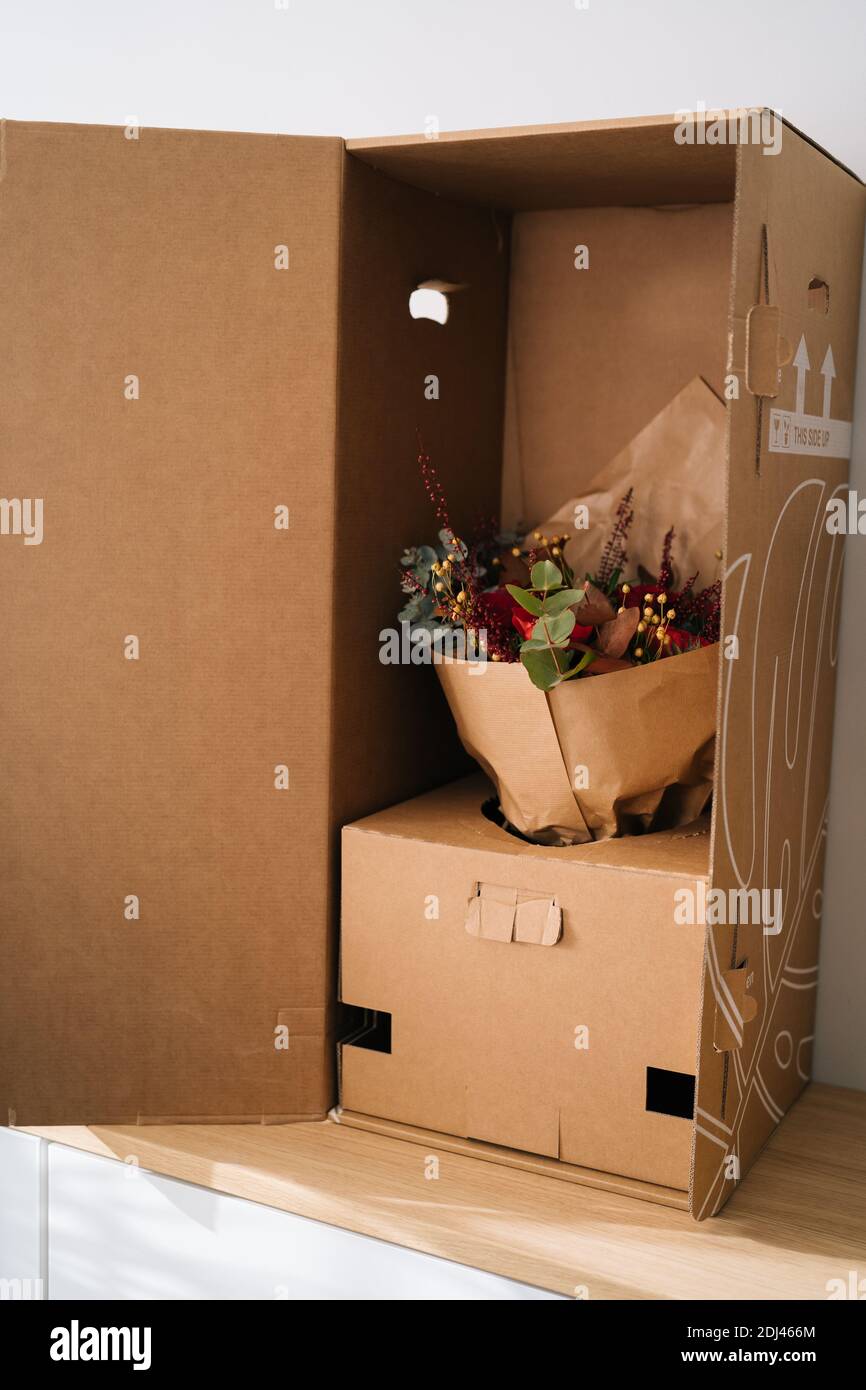 Élégant bouquet de fleurs arrangement par fleuriste dans une boîte préparée pour le transport sur une table en bois Banque D'Images