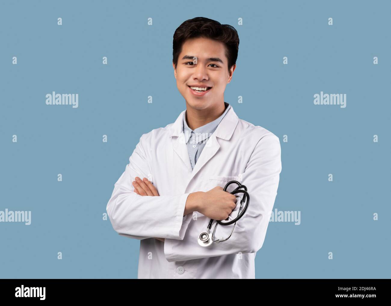 Médecin asiatique en manteau médical posé à la caméra Banque D'Images