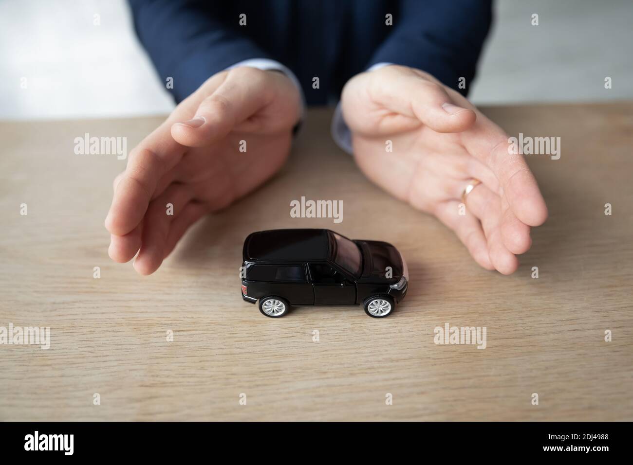 Gros plan homme d'affaires avec une voiture-jouet sur une table de bureau, visualisation Banque D'Images