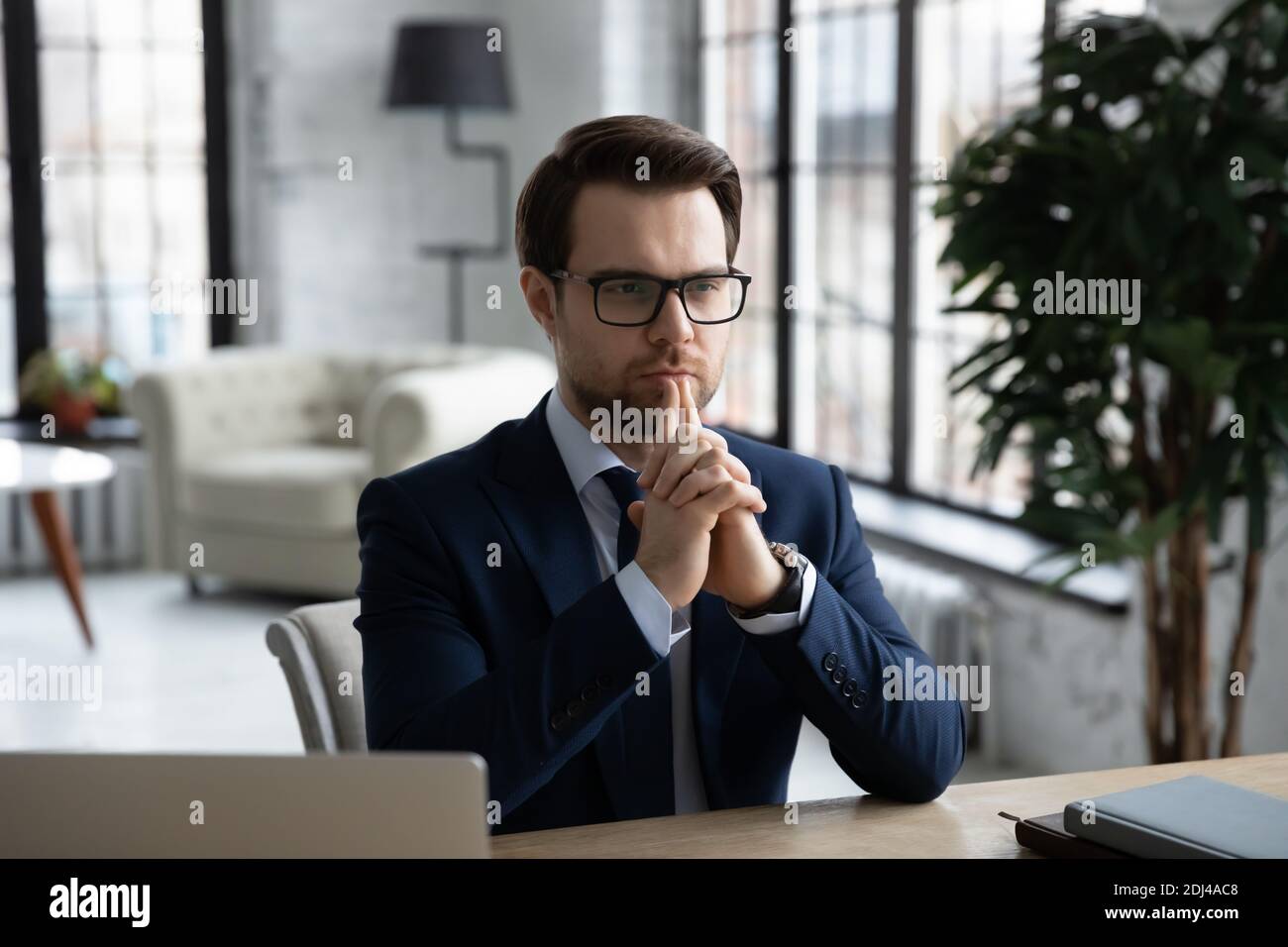 Homme d'affaires confiant et réfléchi portant des lunettes réfléchit à la solution du problème Banque D'Images
