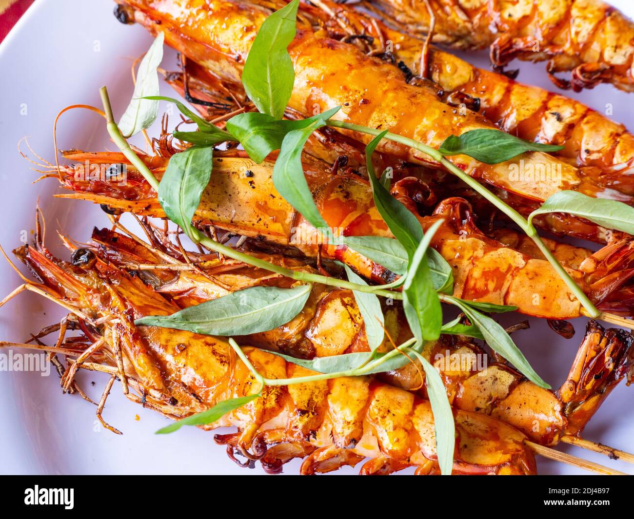 Assiette avec crevettes vietnamiennes au barbecue et herbes locales dans un restaurant le long de la rivière Dinh près de Vung Tau, dans le sud du Vietnam. Banque D'Images