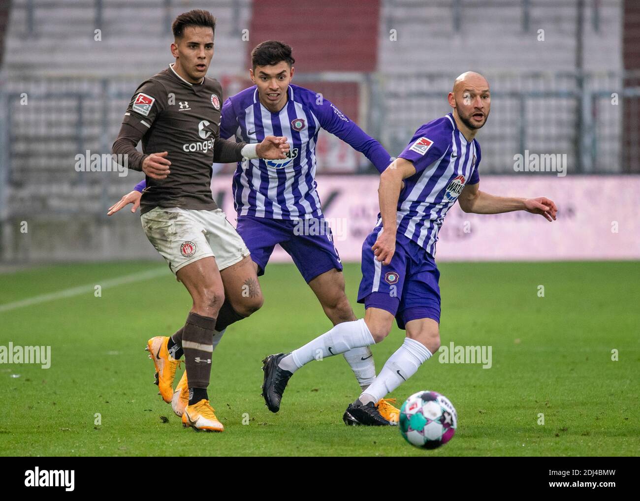 13 décembre 2020, Hambourg: Football: 2ème Bundesliga, FC St. Pauli - Erzgebirge Aue, 11ème match. Saint Paulis Rodrigo Zalazar (l-r), Aues John-Patrick Strauß et Aues Philipp Riese se battent pour le ballon. Photo: Axel Heimken/dpa - NOTE IMPORTANTE: Conformément aux règlements de la DFL Deutsche Fußball Liga et de la DFB Deutscher Fußball-Bund, il est interdit d'exploiter ou d'exploiter dans le stade et/ou à partir du jeu pris des photos sous forme d'images de séquence et/ou de séries de photos de type vidéo. Banque D'Images