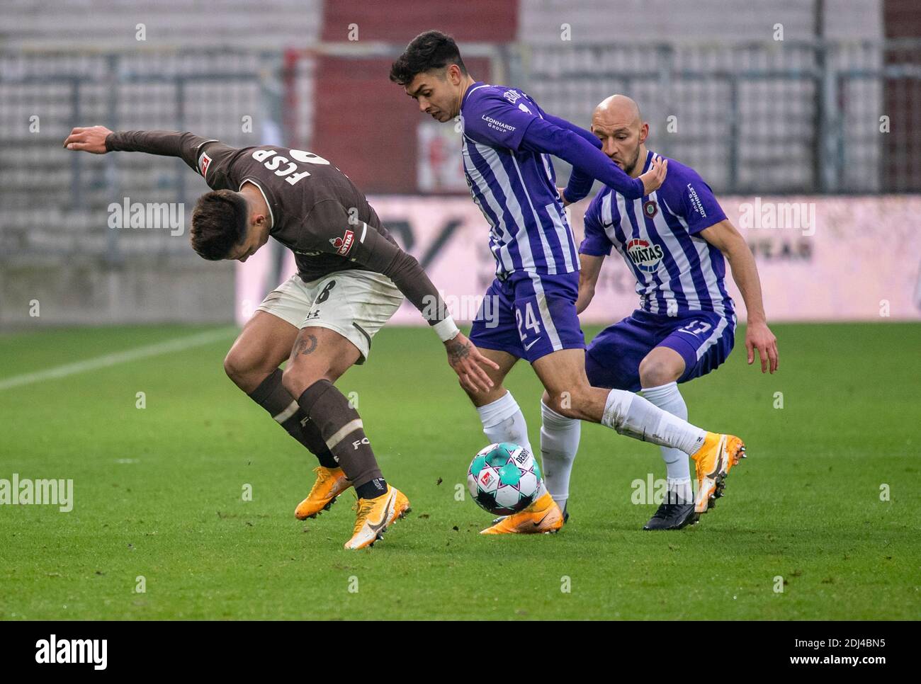 13 décembre 2020, Hambourg: Football: 2ème Bundesliga, FC St. Pauli - Erzgebirge Aue, 11ème match. Saint Paulis Rodrigo Zalazar (l-r), Aues John-Patrick Strauß et Aues Philipp Riese se battent pour le ballon. Photo: Axel Heimken/dpa - NOTE IMPORTANTE: Conformément aux règlements de la DFL Deutsche Fußball Liga et de la DFB Deutscher Fußball-Bund, il est interdit d'exploiter ou d'exploiter dans le stade et/ou à partir du jeu pris des photos sous forme d'images de séquence et/ou de séries de photos de type vidéo. Banque D'Images