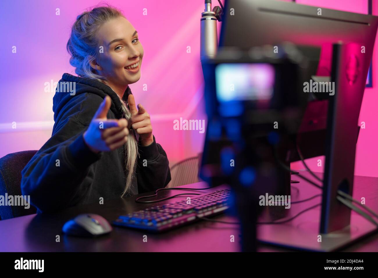 Amusant et souriant e-sport gamer fille vlogging et joue en ligne Jeu vidéo sur PC Banque D'Images