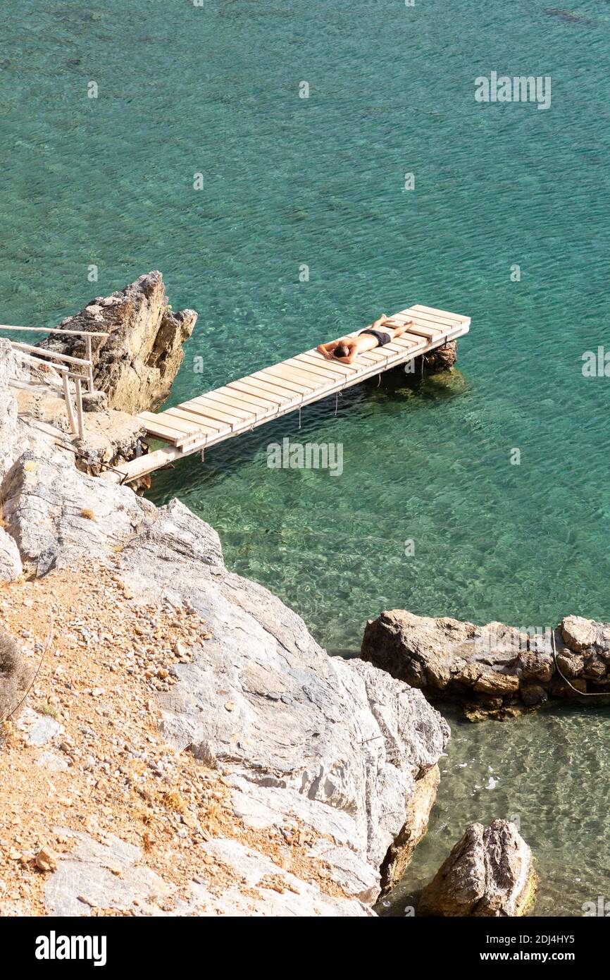 Un homme se bronzer sur une petite jetée en bois à la plage de Preveli, Crète, Grèce Banque D'Images