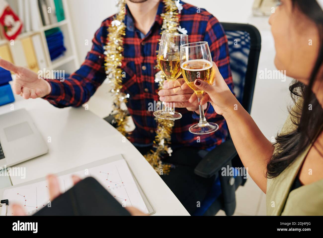 Image rognée de gens d'affaires buvant du champagne après la fin du travail sur le rapport annuel Banque D'Images