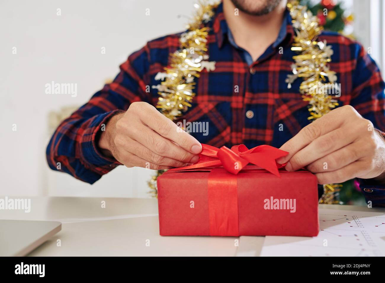 Image rapprochée de l'homme d'affaires qui a déballé le cadeau du nouvel an à son bureau Banque D'Images