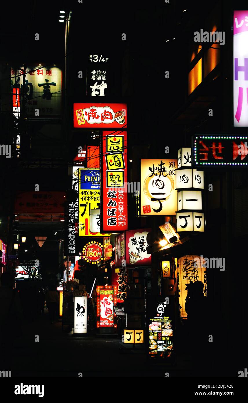 Néons et panneaux publicitaires dans la rue d'Osaka, au Japon. Tableau lumineux à contraste élevé avec enseignes lumineuses Banque D'Images