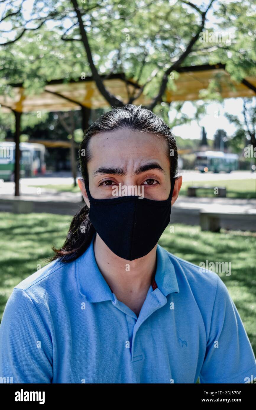 jeunes hommes avec une expression indécise du visage, avec un collier, masque facial Banque D'Images