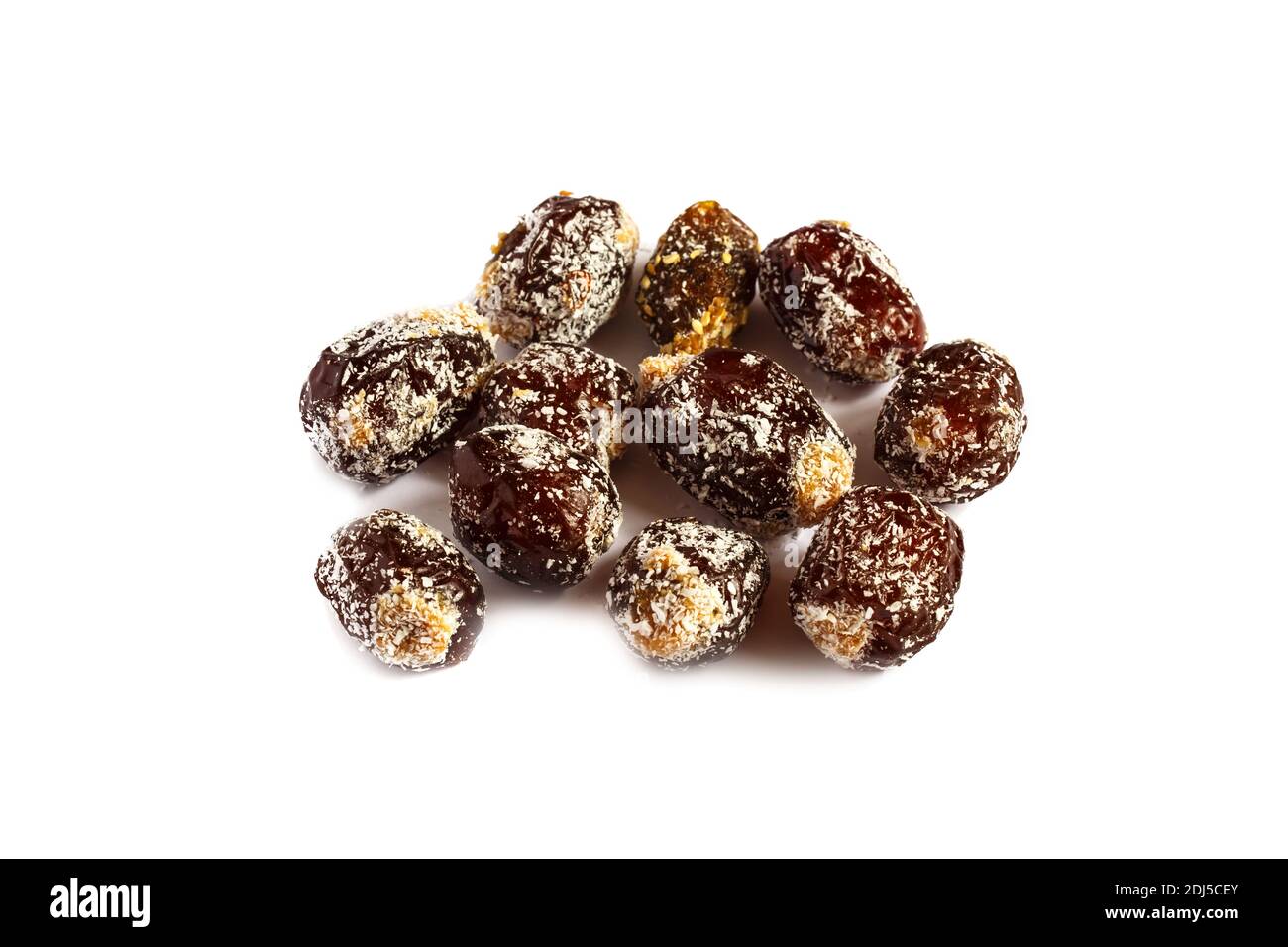 Dattes piquées isolées sur fond blanc. Dattes remplies de beurre d'arachide et parsemées de flocons de noix de coco Banque D'Images