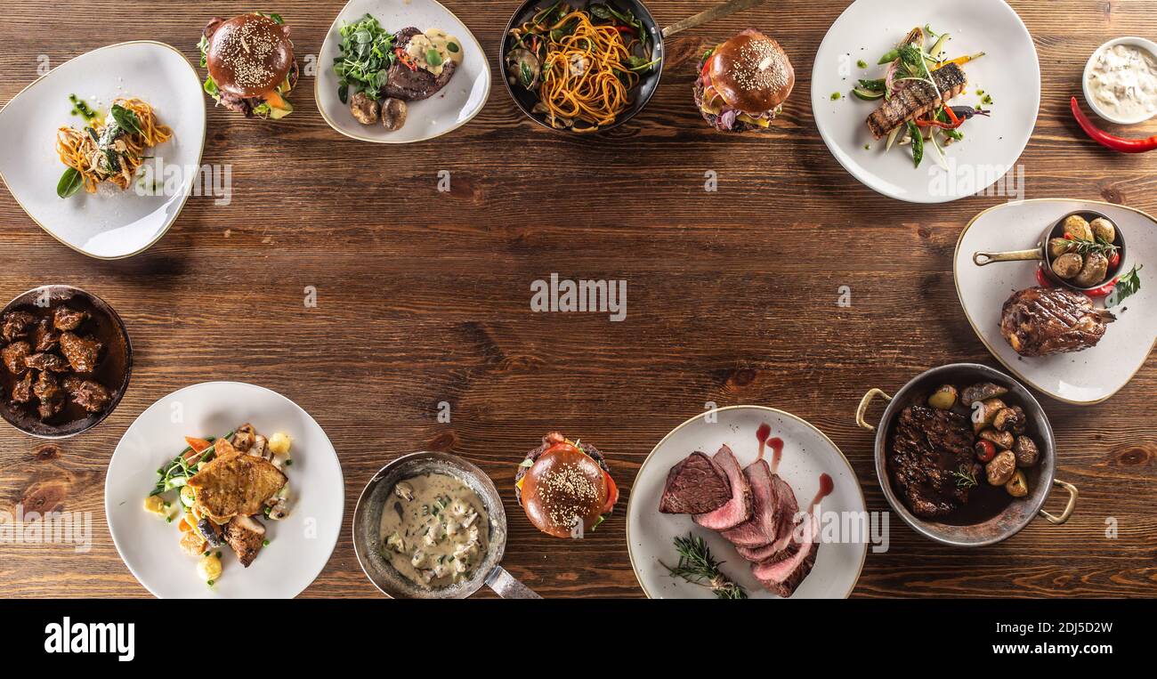 Vue de dessus d'une table pleine de divers repas pour les végétariens et les mangeurs de viande servis dans un cercle. Banque D'Images