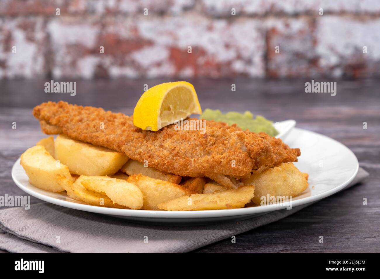 Morue panée frite avec frites et petits pois Banque D'Images