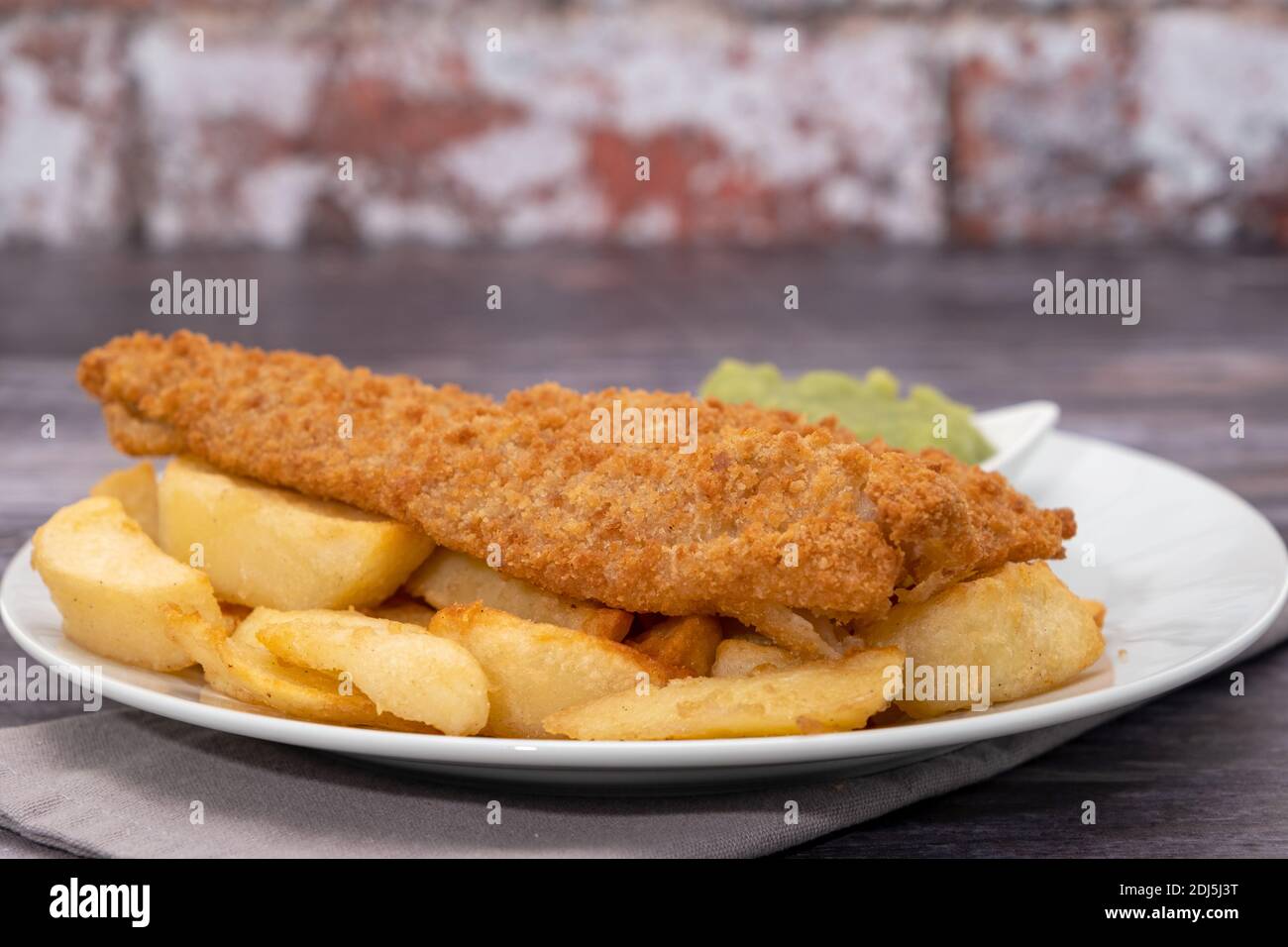 Morue panée frite avec frites et petits pois Banque D'Images