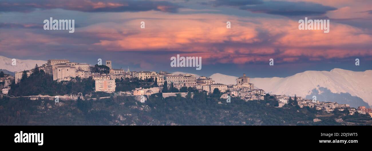 Vue panoramique sur la ville de Veroli avec des montagnes enneigées et un coucher de soleil spectaculaire au loin. Banque D'Images