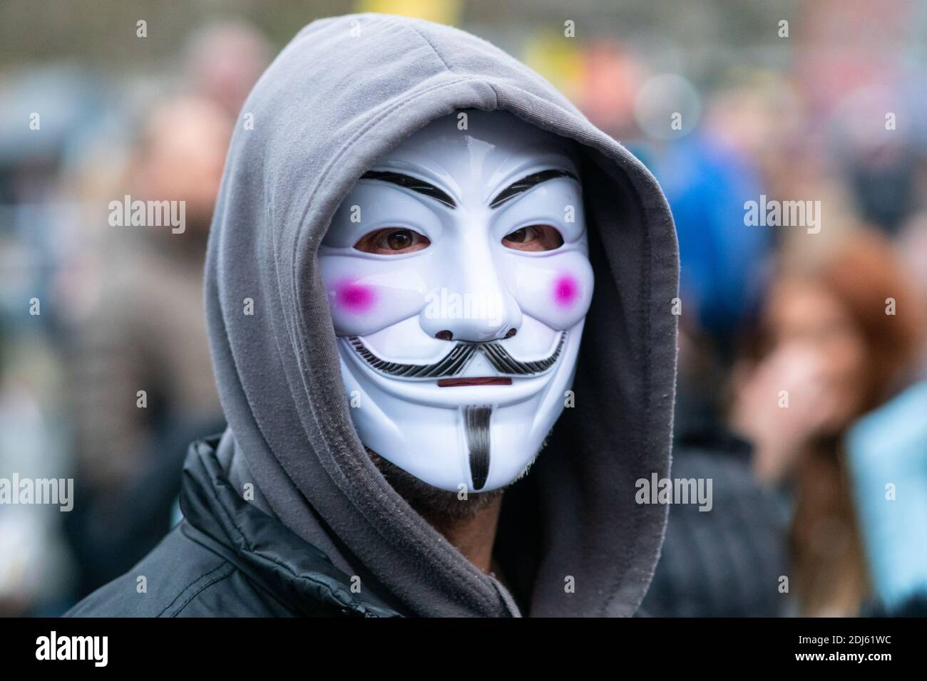 Manchester Sam 12 décembre 2020. Manifestation contre les restrictions de la liberté/lutte contre la COVID-19, Piccadilly Gardens. Homme portant Guy Fawkes ou masque anonyme avec capuche Banque D'Images