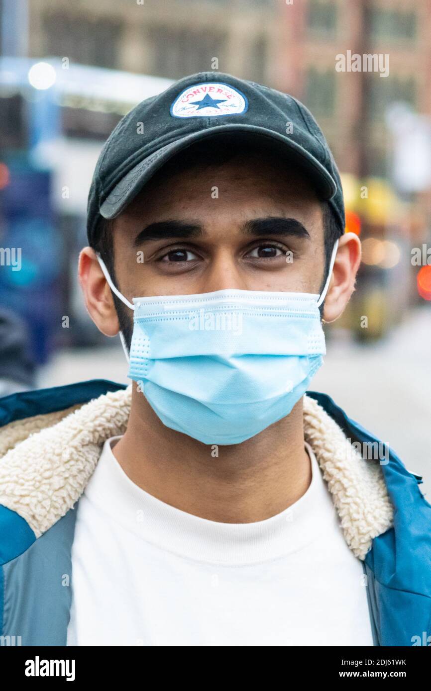 Manchester décembre 2020. Un jeune homme portant son masque facial dans les rues, qui étaient occupés par des clients de Noël et des manifestants. Portrait Banque D'Images