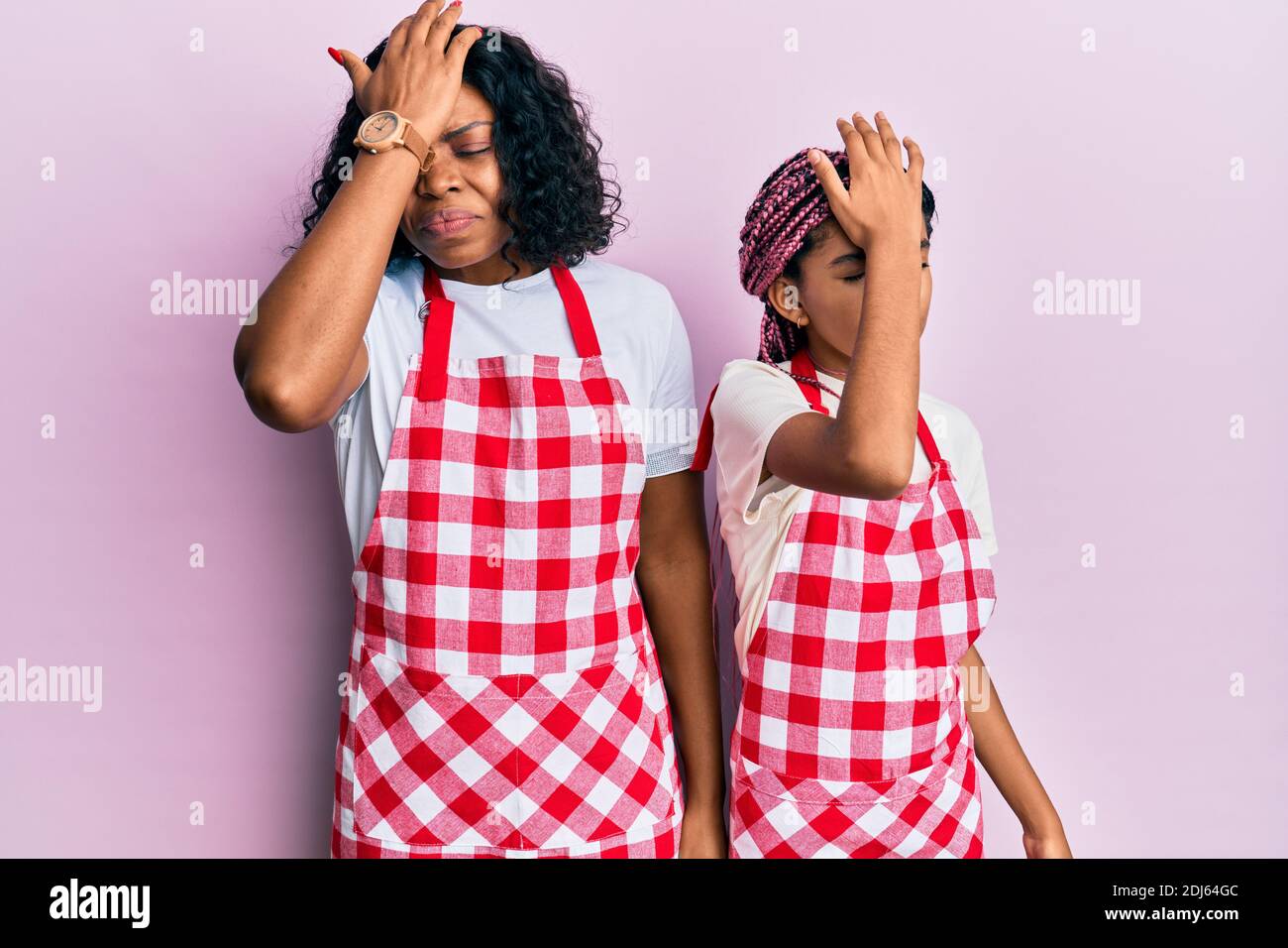 Belle mère africaine américaine et fille portant l'uniforme de boulanger surpris avec la main sur la tête pour l'erreur, se souvenir de l'erreur. oublié, mauvais mémoire conce Banque D'Images Belle mère africaine américaine et fille portant l'uniforme de boulanger surpris avec la main sur la tête pour l'erreur, se souvenir de l'erreur. oublié, mauvais mémoire conce Banque D'Images