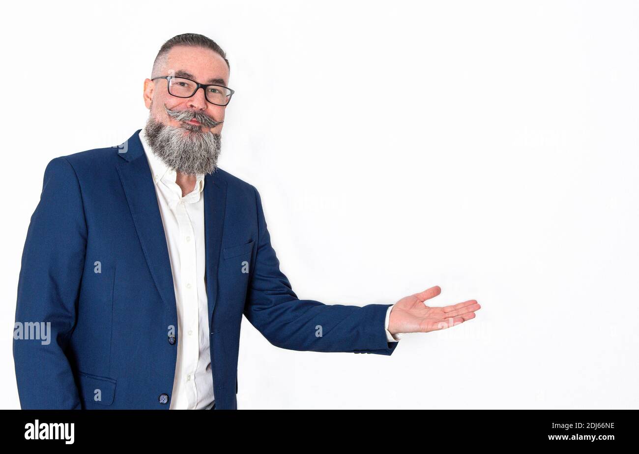 homme avec une grande barbe et des lunettes regardant droit devant et bras étendu sur le côté pointant vers l'espace de copie dans lequel inclure votre texte, produit o Banque D'Images