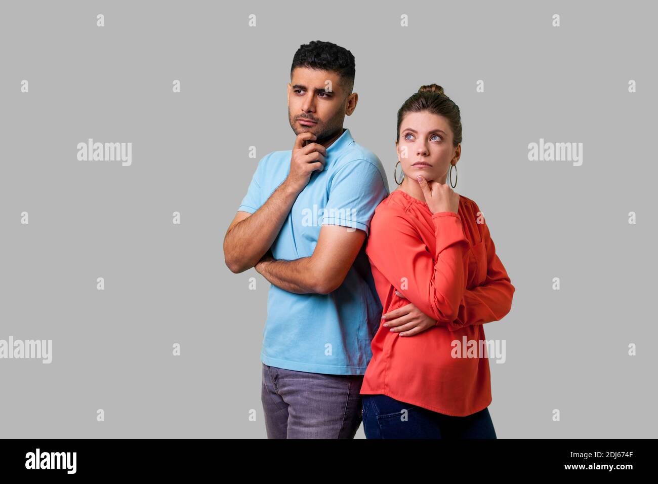 Plan de penser ! Portrait of attractive young couple smart casual wear en position debout, tenant le menton en pensant solution ensemble en haut. est Banque D'Images