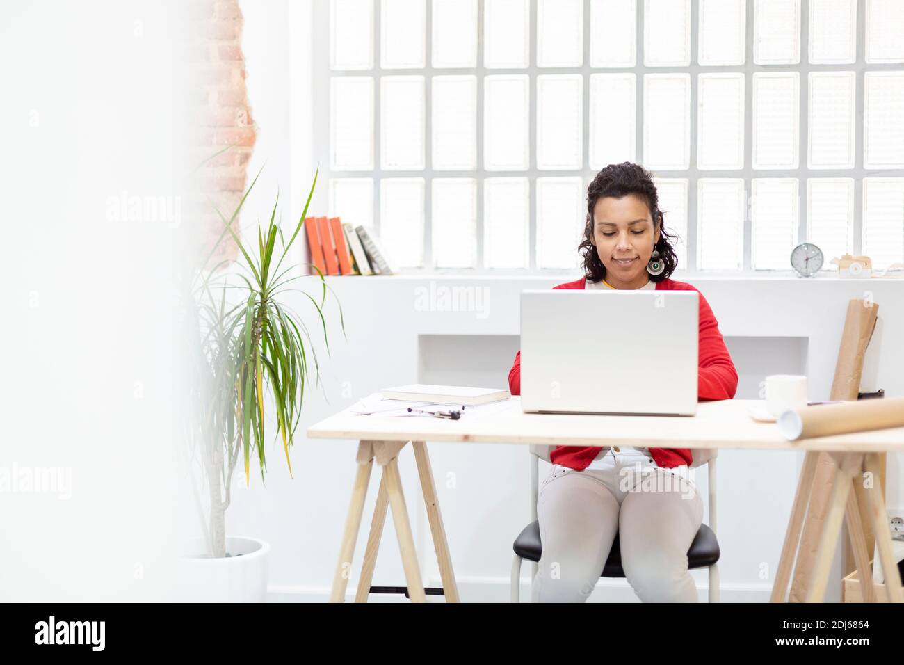 Jeune designer femme utilisant son ordinateur portable dans son studio moderne. Espace pour le texte. Concept de travail à domicile. Banque D'Images