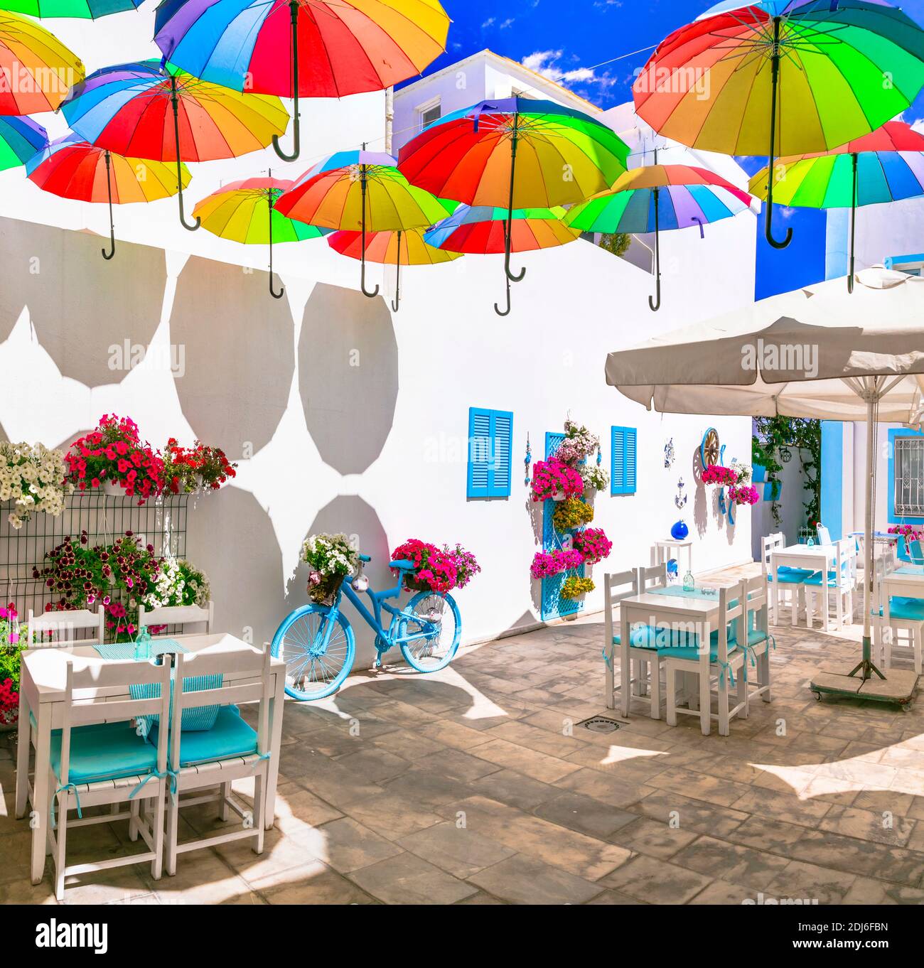 Belle décoration de bar de rue (restaurant) avec parasols colorés, vélo d'époque et fleurs Banque D'Images