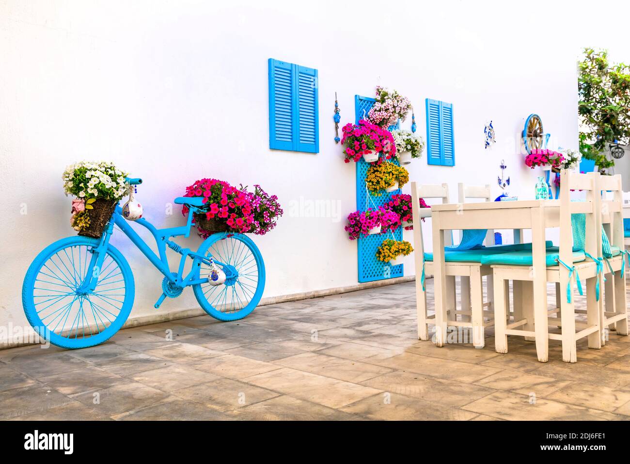 Belle décoration de bar de rue (restaurant) avec parasols colorés, vélo d'époque et fleurs Banque D'Images