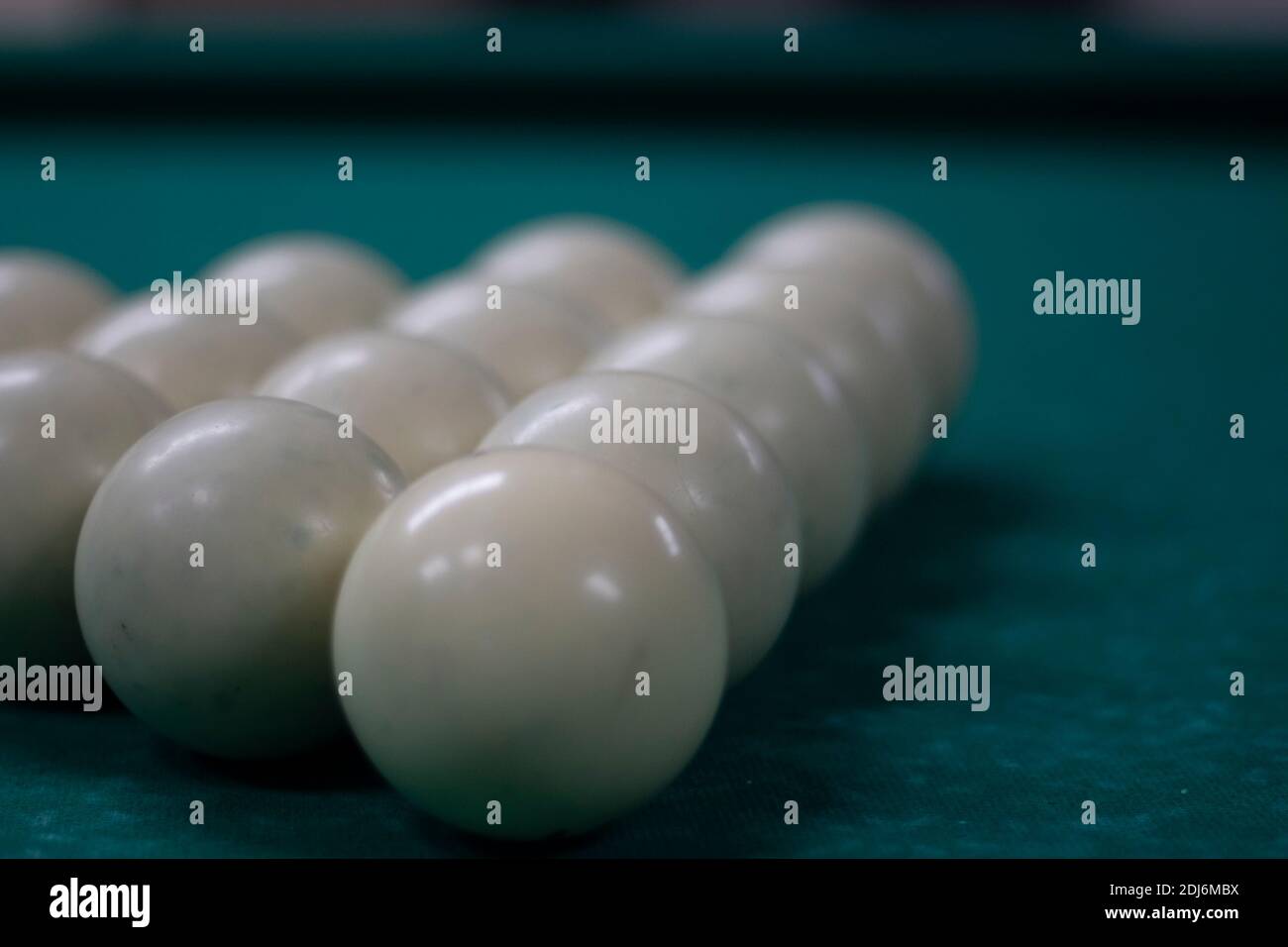 Partie de billard. Boules de billard sur la table. Lumière tamisée dans la salle de billard. Boules blanches sur une surface de table verte. Banque D'Images