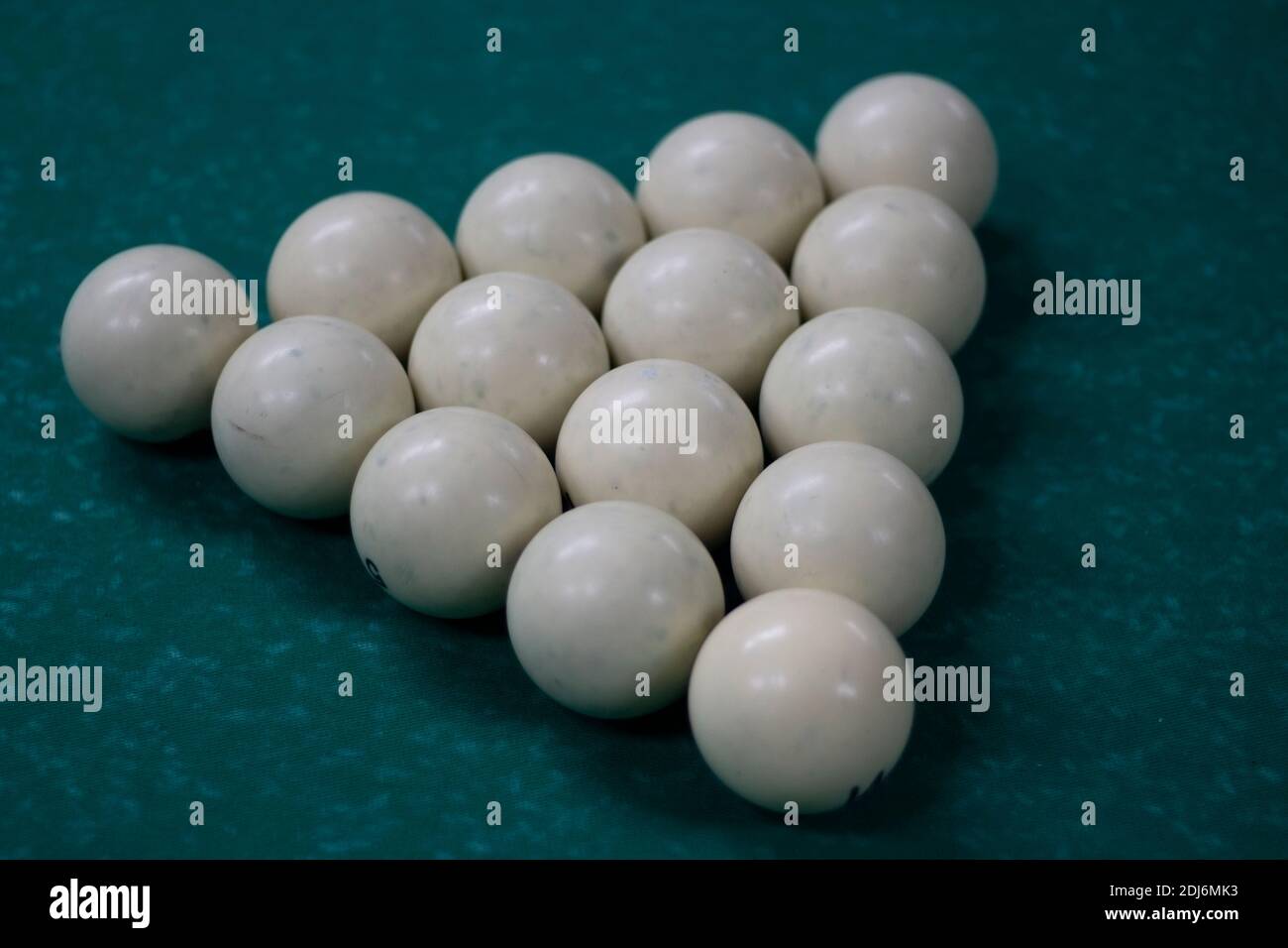 Partie de billard. Boules de billard sur la table. Lumière tamisée dans la salle de billard. Boules blanches sur une surface de table verte. Banque D'Images