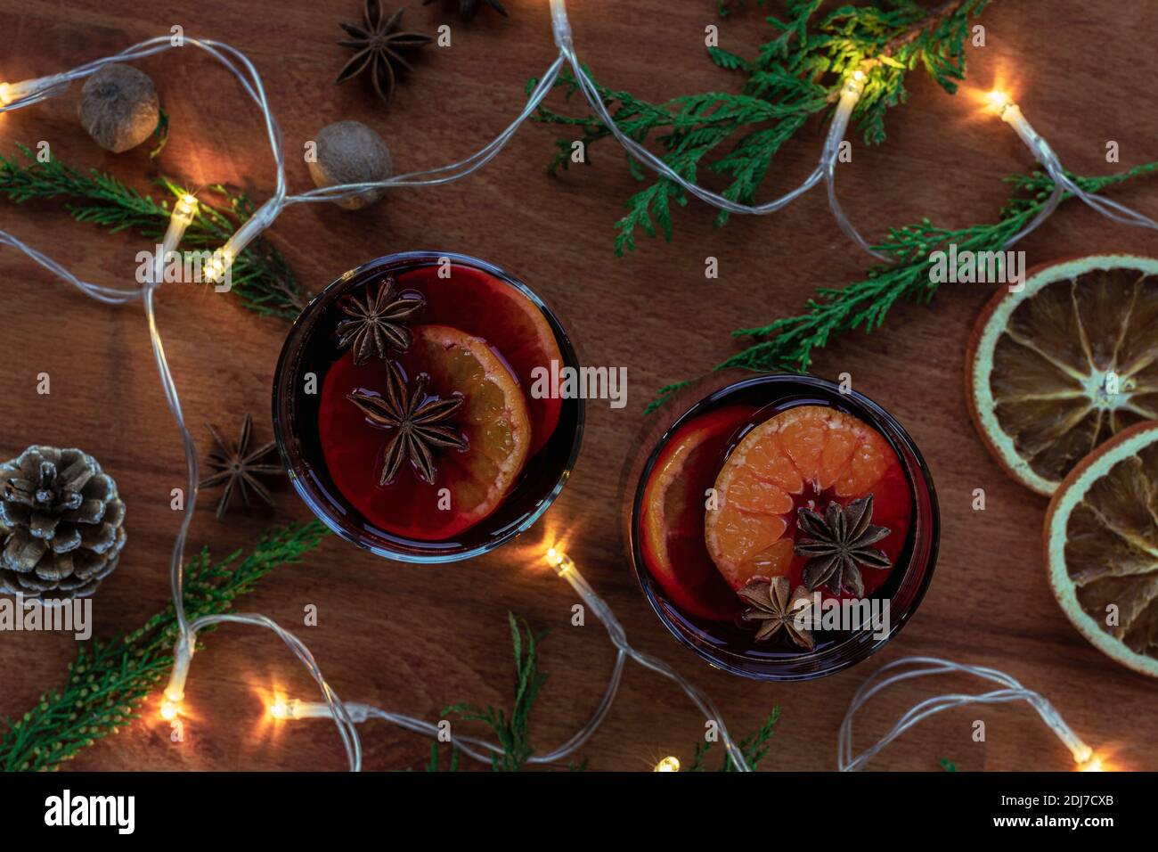 Deux verres de vin chaud aux agrumes, anis étoilé, muscade sur table en bois. Boisson de Noël de saison, décorations et lumières du nouvel an, t Banque D'Images