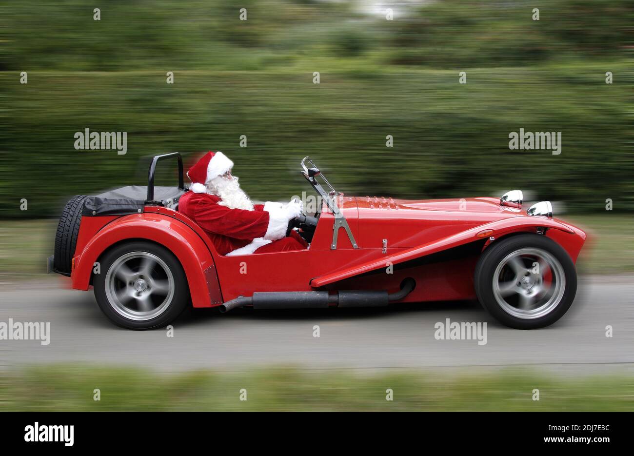 Père Noël conduite d'une voiture de sport rouge pour une grande image Carte de Noël Banque D'Images