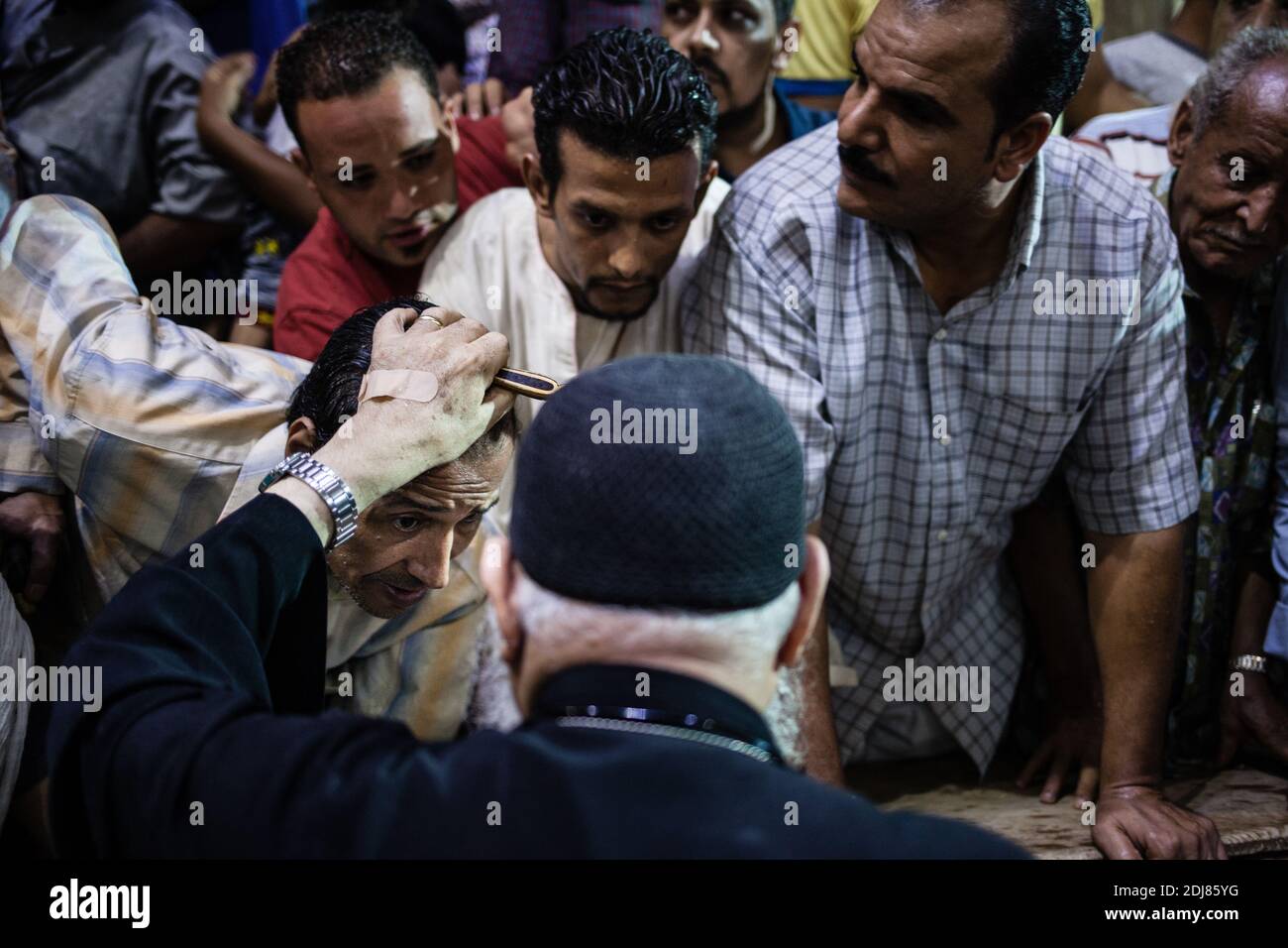 PAS DE WEB/PAS D'APPS - le prêtre copte, le père Samaan Ibrahim, effectue une session d'exorcisme à l'église Saint Samaan (Simon), également connue sous le nom d'église Cave dans le village de Mokattam, surnommée "ville des ordures", au Caire, en Égypte, le 19 août 2016. Une fois par semaine, des centaines de musulmans se rassemblent à l'église après la prière pour assister à une session d'exorcisme réalisée par le prêtre. Avec une croix et une eau sainte, il combat les entités spirituelles et les démons. Le monastère possède un amphithéâtre d'une capacité de 20,000 places, ce qui en fait la plus grande église chrétienne du Moyen-Orient. Il porte le nom du Saint copte, SIM Banque D'Images