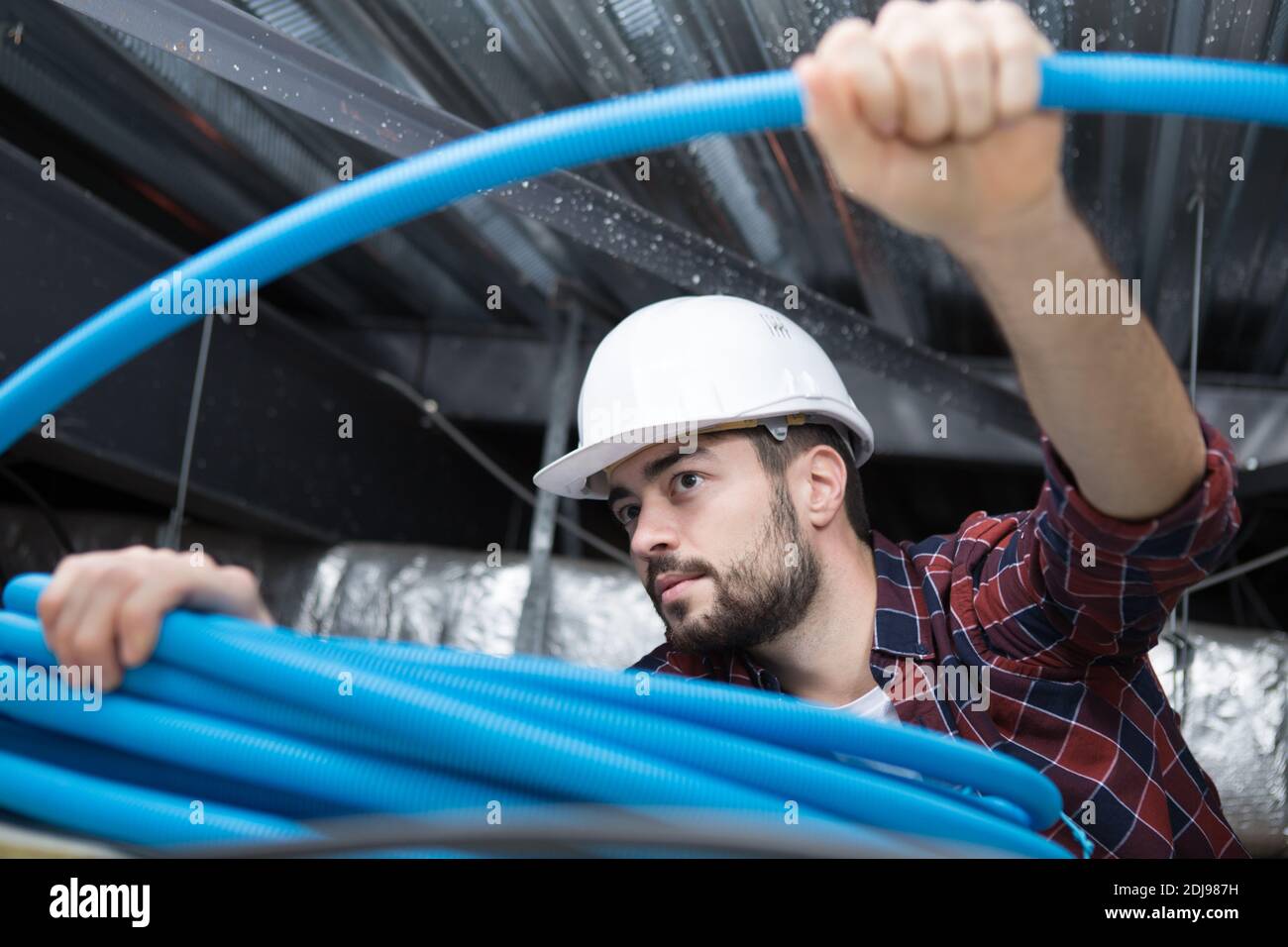 plombier travaillant avec des tuyaux à l'intérieur Banque D'Images