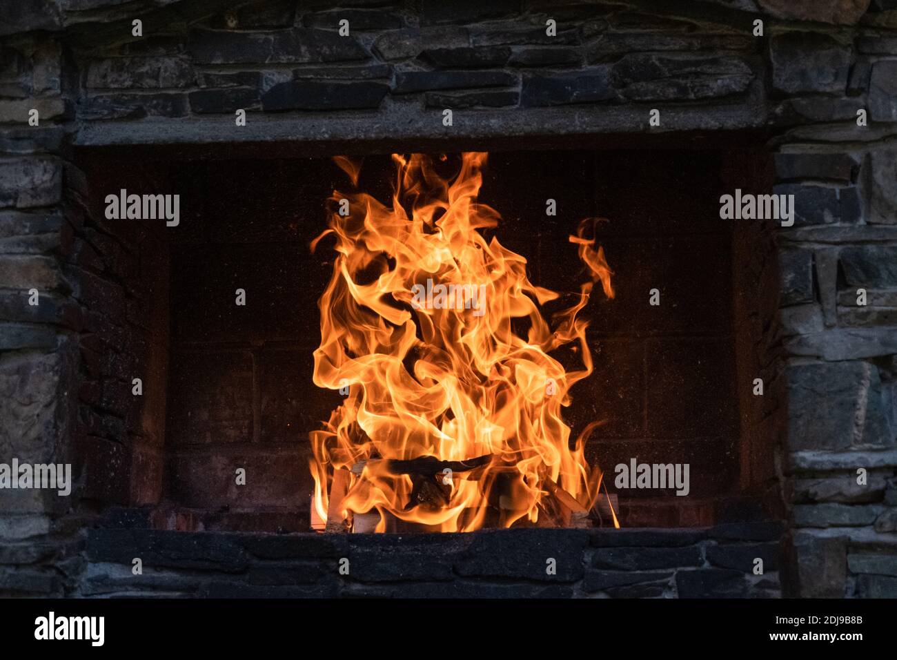 Belle cheminée dans le jardin rouge flammes en pierre. Endroit pour se détendre, cuisiner Banque D'Images