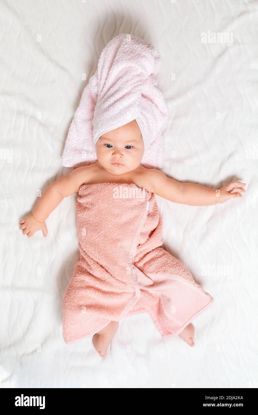 Un Mignon Bebe Caucasien Enveloppe Dans Une Serviette Rose Sur Une Feuille Blanche Vue Du Dessus Bebe Apres Le Bain Photo Stock Alamy
