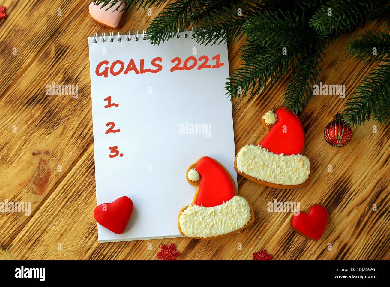 Cahier blanc pour les objectifs de Noël, résolution, plan pour la nouvelle année 2021. Pains d'épices comme chapeau et coeur du Père Noël, arbre de Noël, décorations Banque D'Images