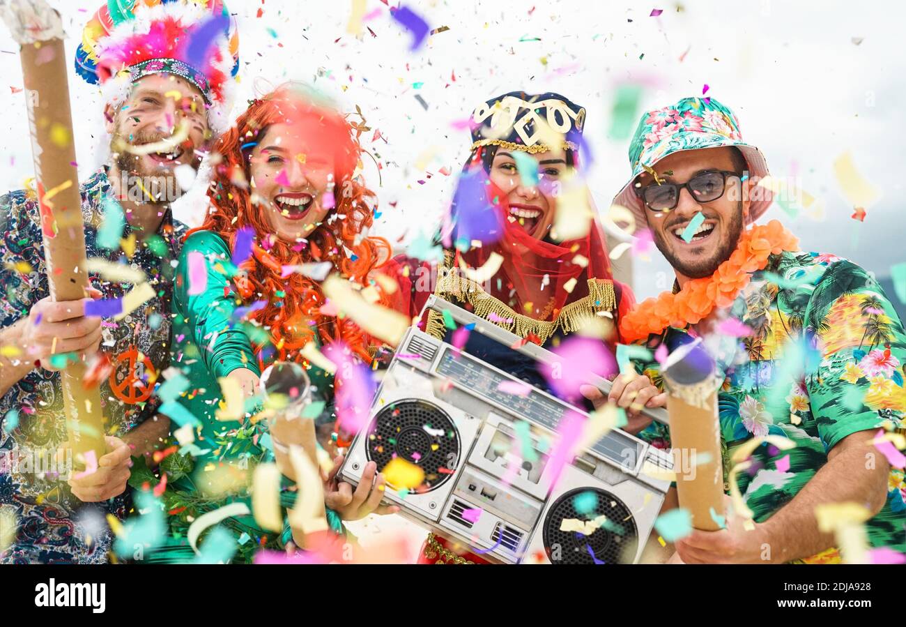 Les jeunes portent des costumes colorés célébrant le lancement d'un événement de fête de carnaval confettis en plein air Banque D'Images