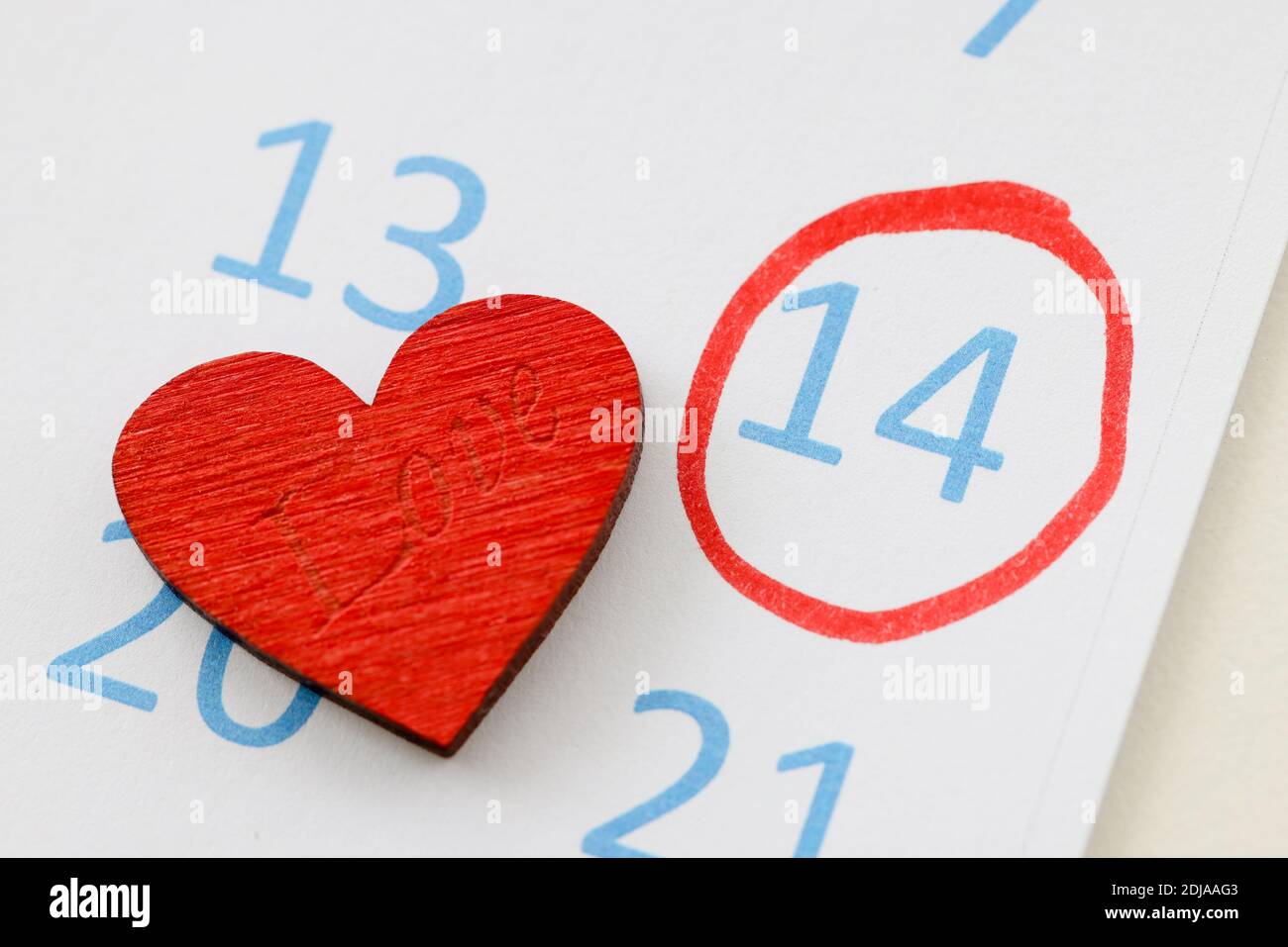 Le numéro 14 est entouré d'un stylo rouge sur le calendrier près du jouet cœur Banque D'Images