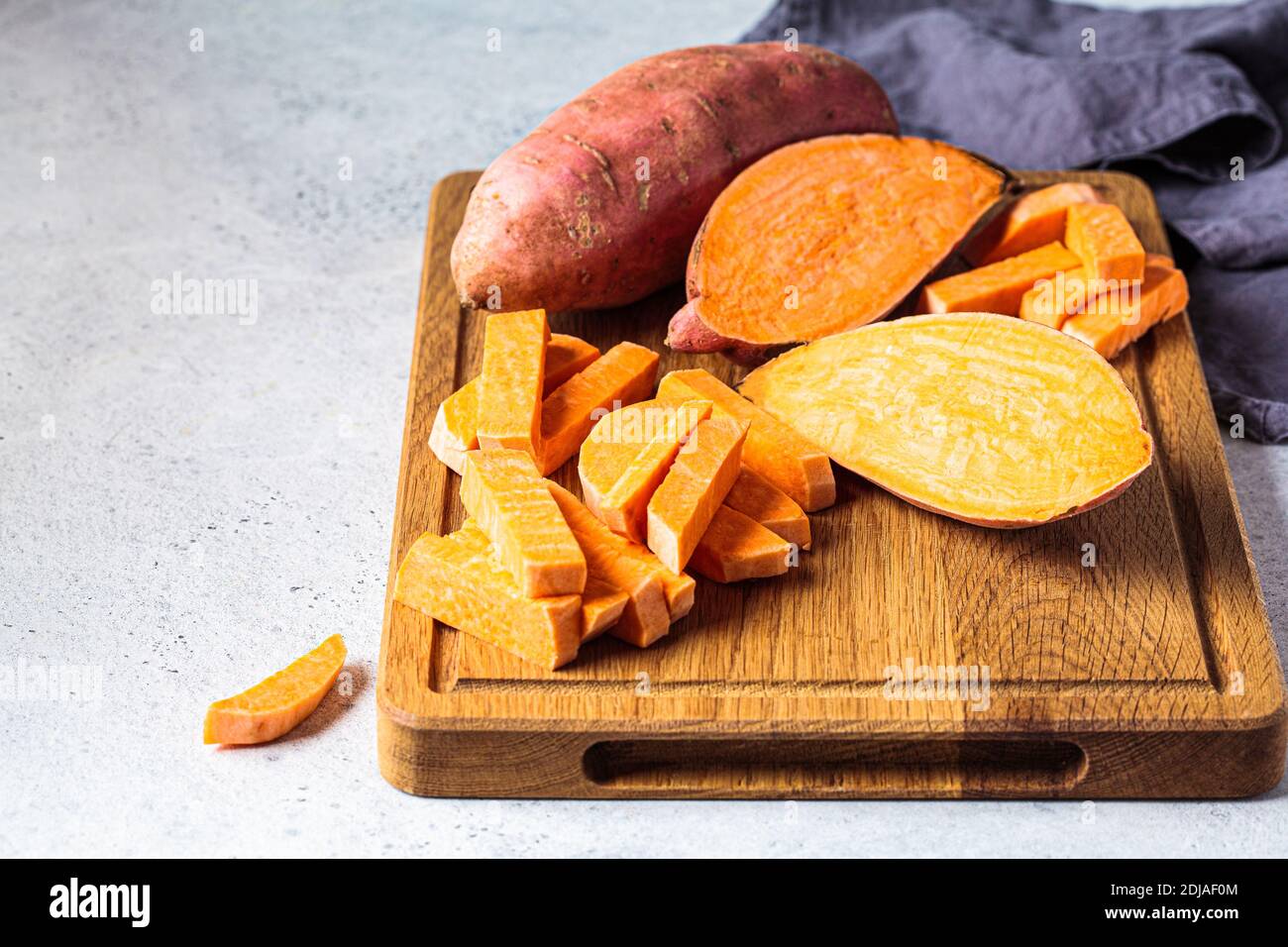 Patates douces en tranches crues sur une planche de bois. Cuisine saine concept Photo Stock Alamy