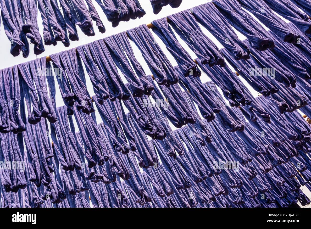 Soie teint bleu suspendue dans une usine de tissage de tissus à Amarapura, Myanmar Banque D'Images