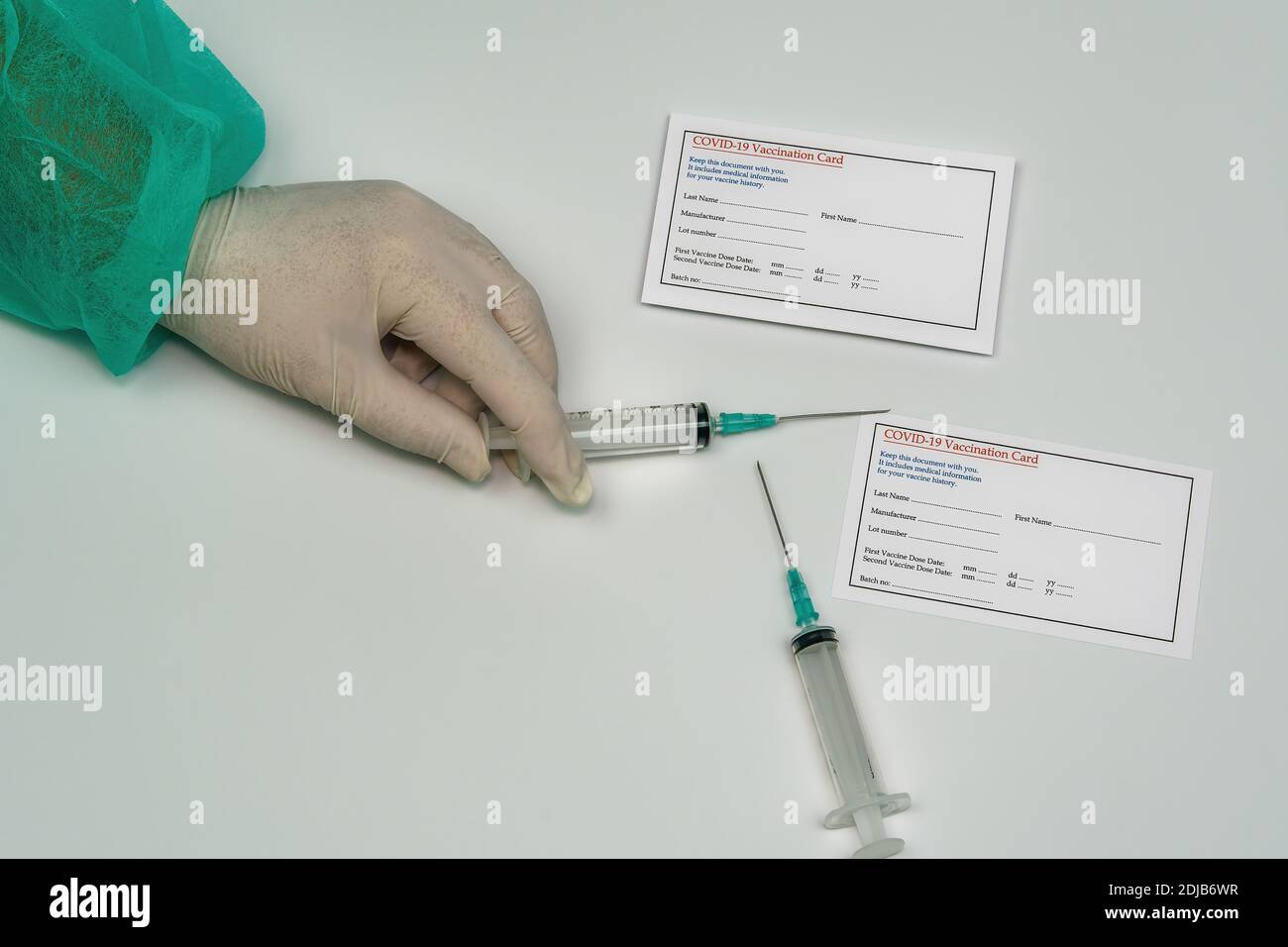 Carte de vaccination Covid-19 concept médical avec seringue de maintien de pharmacien.main avec combinaison et gants à côté de la carte pour le vaccin de protection du coronavirus. Banque D'Images