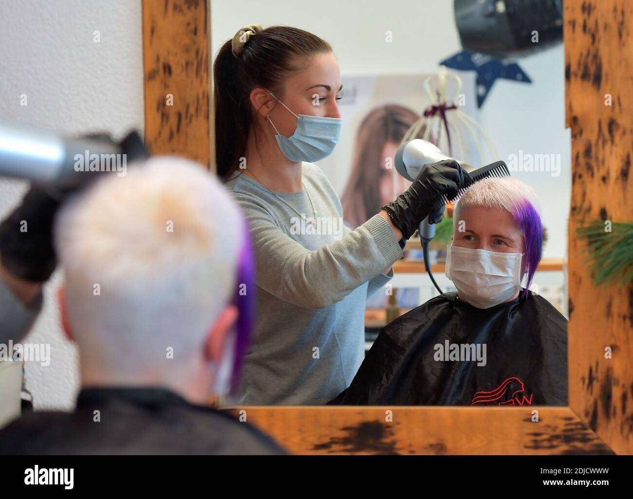 La coiffeuse Nicole Kretschmer travaille dans son salon avant sa fermeture en raison du confinement de la maladie du coronavirus (COVID-19), à Dresde, Allemagne le 14 décembre 2020. REUTERS/Matthias Rietschel Banque D'Images