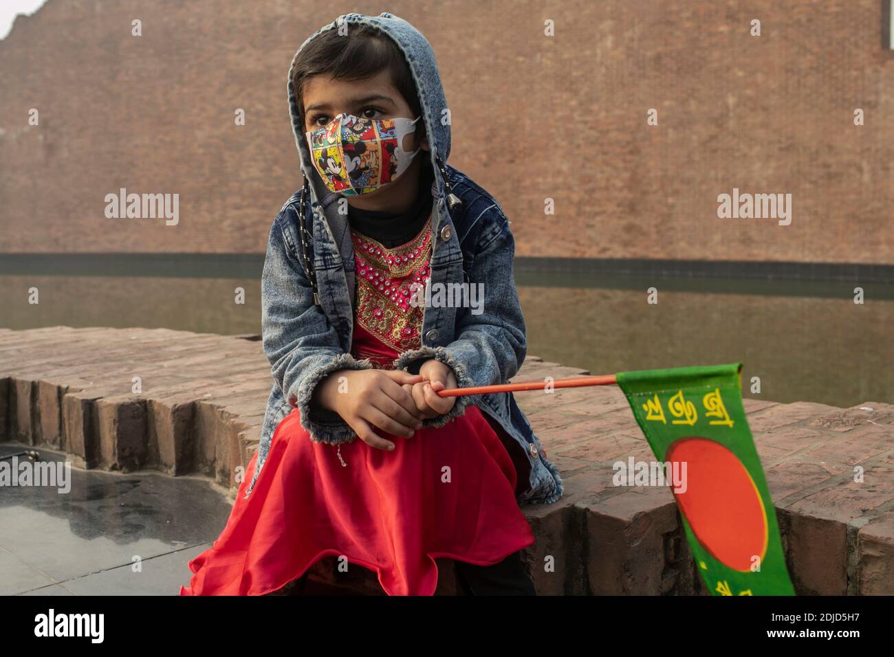 Un enfant bangladais tient une petite bannière du drapeau bangladais en hommage aux dizaines d'intellectuels tués il y a 49 ans pendant la guerre.des milliers de bangladais rendent hommage aux dizaines d'intellectuels tués il y a 43 ans pendant la guerre qui a gagné l'indépendance du pays d'Asie du Sud Du Pakistan. Les intellectuels ont été systématiquement tués dans l'ancien Pakistan oriental par l'armée pakistanaise et leurs collaborateurs pour mutiler la nation émergente de son peuple doué et intellectuel. Banque D'Images